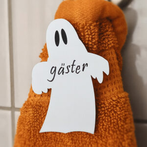 vitt spöke med texten gäster ingraverat i svart. Sitter på orange gästhandduk. Hygienisk och dekorativt till Halloween